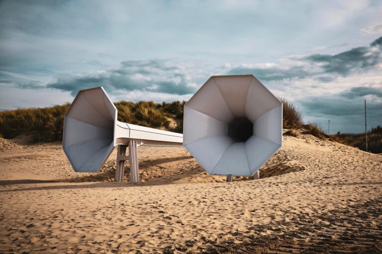 Spiaggia con sabbia che emette suoni melodiosi sotto i piedi, circondata da cartelli di protezione.